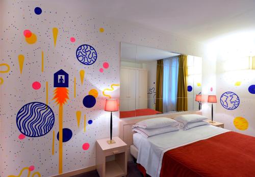 a bedroom with a bed and a wall covered in stickers at Phi Hotel Bologna in Bologna