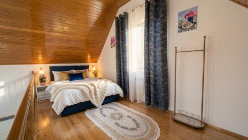 a bedroom with a bed and a wooden ceiling at A-frame-WHITE HOUSE-I in Qusar