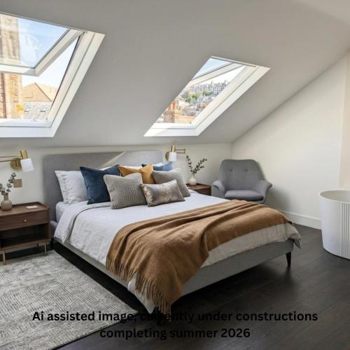an attic bedroom with a bed and two skylights at Uno By The Sea - Boutique Hotel in St Ives