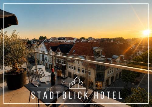a view from a balcony of a building with the sunset at StadtBlick Hotel in Bad Salzuflen