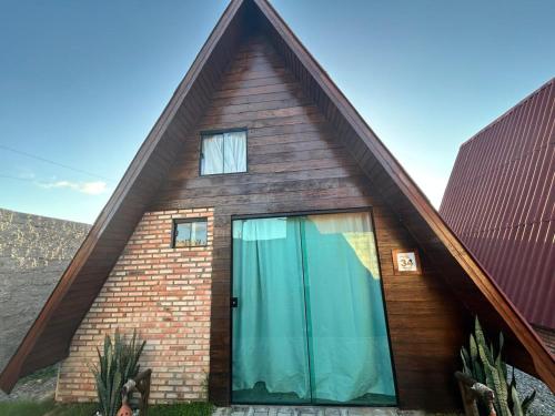 a house with a gambrel roof and a glass door at Pousada Villa Al Mare in Luis Correia