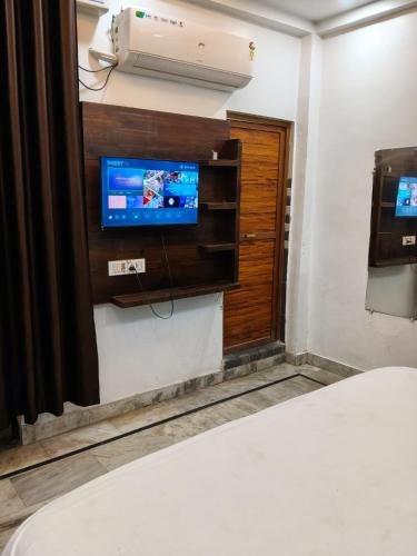 a room with a bed and a tv and a bed gmaxwell gmaxwell gmaxwell at Hotel Downtown in Kānpur