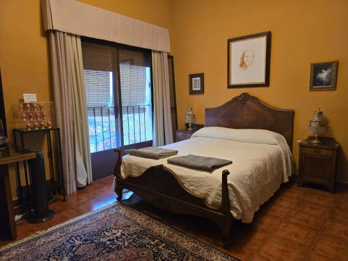 a bedroom with a bed and a large window at Casa Aurea in Begíjar