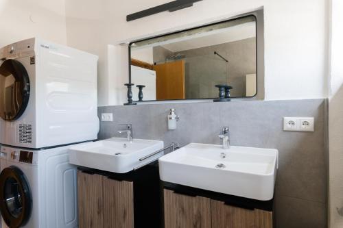 a bathroom with two sinks and a washing machine at 21 Pure relaxation Apartment in Memmingerberg