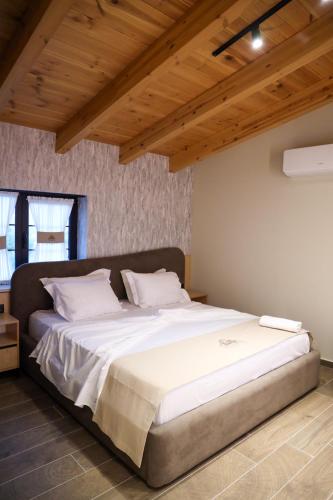 a large bed in a room with wooden ceilings at Kruja Gate in Krujë