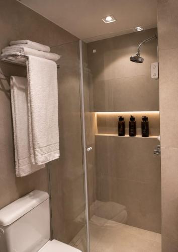 a bathroom with a shower with a toilet and towels at TFL EXECUTiVE PREMIUM FARIA LIMA - ITAIM in São Paulo