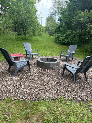 three chairs and a fire pit in a yard at Chalet Oh Deer ! Spa et bois pour feu inclus in Entrelacs