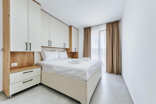 a bedroom with a white bed and a large window at Malik Bay RESIDENTS in Bar
