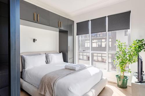 a bedroom with a white bed and a large window at The Lookout in Cape Town