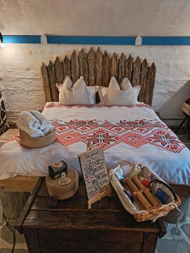 a bed with pillows and a sign on a table at Nook Hill in Comarnic