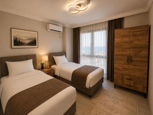 a hotel room with two beds and a window at Airport Deluxe Suites Otel in Trabzon