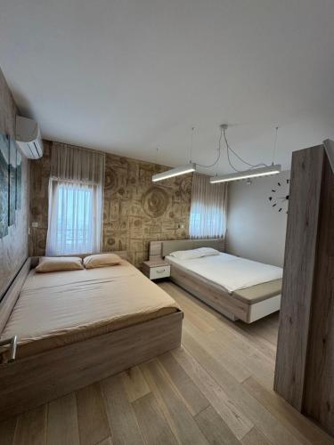 two beds in a large room with wooden floors at Azure Residence in Pržno