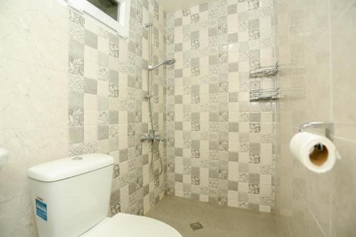 a bathroom with a toilet and a roll of toilet paper at Qiwi House in Ureki