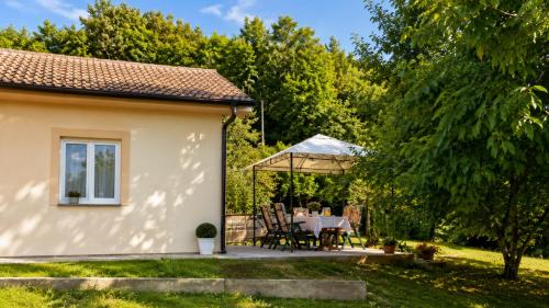 a cottage with a table and a gazebo at Terra Verde in Račički Brijeg