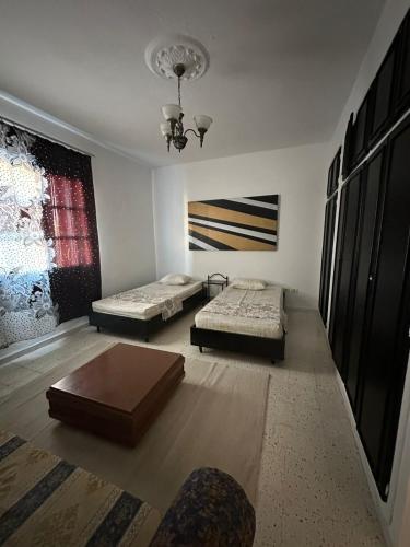 a room with two beds and a table in it at Appartement henda 04 in Sousse