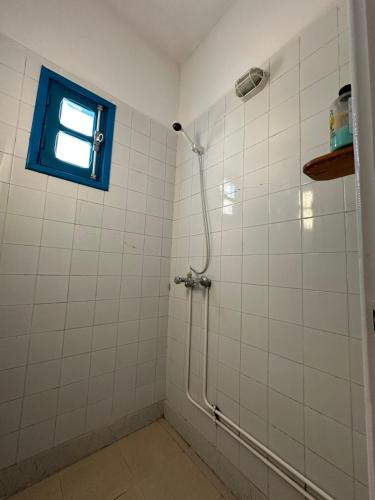 a bathroom with a shower with a blue window at Appartement henda 04 in Sousse
