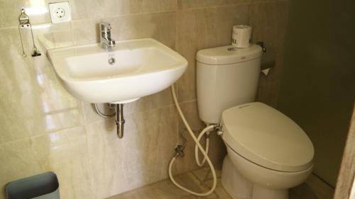 a bathroom with a toilet and a sink at Sugiras Living in Denpasar