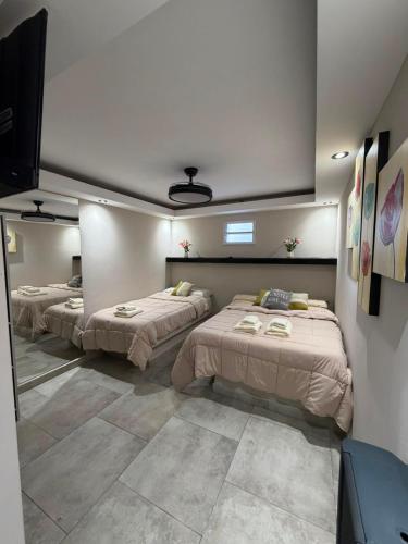 a room with three beds and a flat screen tv at Apart hotel in Neuquén