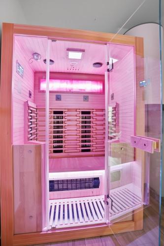 a pink room with a machine in a room at Chalupy Bret v Krkonoších- prostorná chalupa se 3 apartmány, se saunou nebo vířivkou in Žacléř