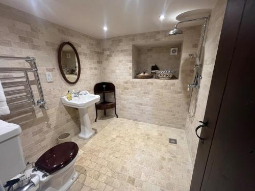 a bathroom with a sink and a toilet and a mirror at Semeil Farm Holiday Lets in Strathdon