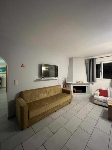 a living room with a couch and a flat screen tv at Vouzianas home in Kefallonia