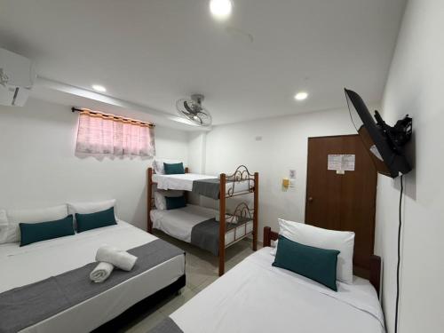 a room with two beds and a tv and a bunk bed at 22 Guest House in Santa Marta