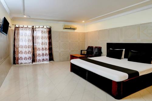 a bedroom with a large bed and a window at Hotel O Meera in Chennai