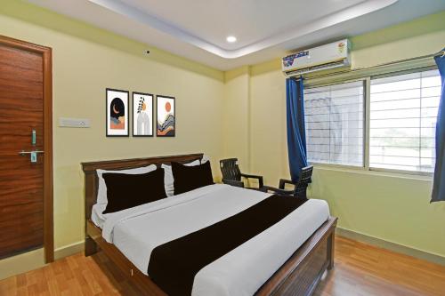 a bedroom with a large bed and a window at HOTEL O MYRAA INN in Surūrnagar