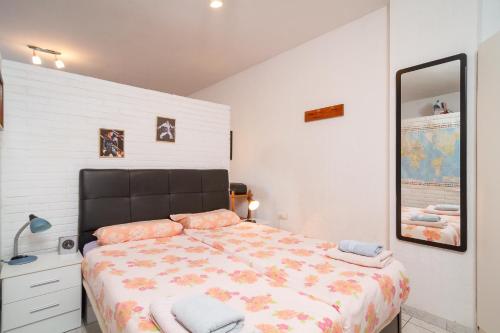 1 dormitorio con 1 cama grande y espejo en Carabeo 16 Studios Casasol, en Nerja