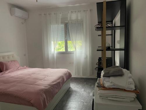 a bedroom with a bed and a window at Durres Garden Stay in Durrës