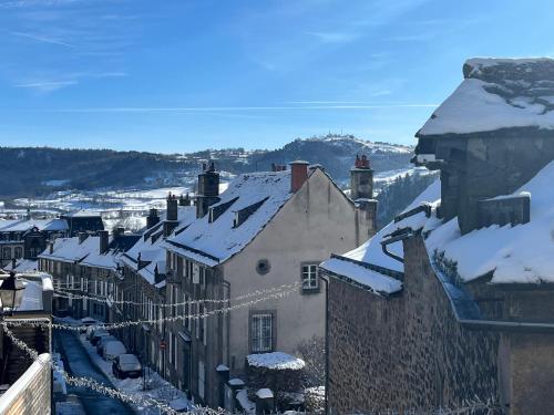 a town with snow on the roofs of buildings at Murat - Le Duplex By Murat in Murat