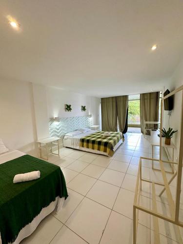 a bedroom with a bed and a table and chairs at Hotel Ibiza in Angra dos Reis