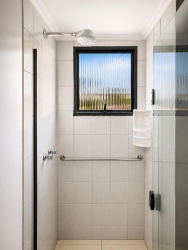 a bathroom with a shower with a glass door at LEON MARIA HOSPEDAGENS - Smart Flat Hotel e Residence in Mogi das Cruzes