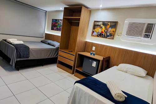 a hotel room with two beds and a tv at Refúgio da Praça: Charme e Conforto in Belém