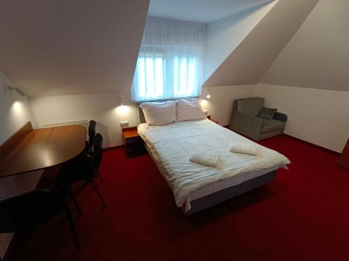 a bedroom with a bed and a desk and a window at Moka in Grzybowo