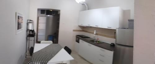 a kitchen with white cabinets and a refrigerator at Aloe in Olympiada