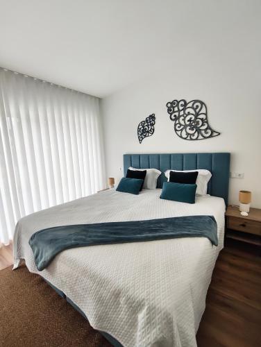 a bedroom with a large bed with a blue headboard at Hotel de Charme Casa Fundevila in Vila Verde