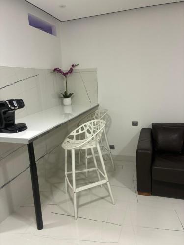 a kitchen with a table and a chair in a room at Studio jardin cap d Agde in Cap d'Agde
