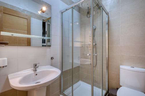 a bathroom with a shower and a sink and a toilet at NEW - 2BR Beach side apt by SF HOMES in Sliema