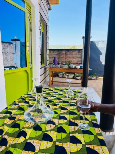 a table with two glasses of wine on a colorful table cloth at Blue Home Stay in Janjagiro