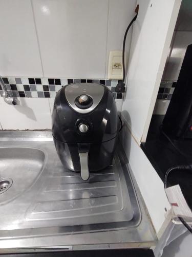a tea kettle sitting on top of a kitchen sink at Apartamento térreo bem equipado, fácil acesso in Canoas