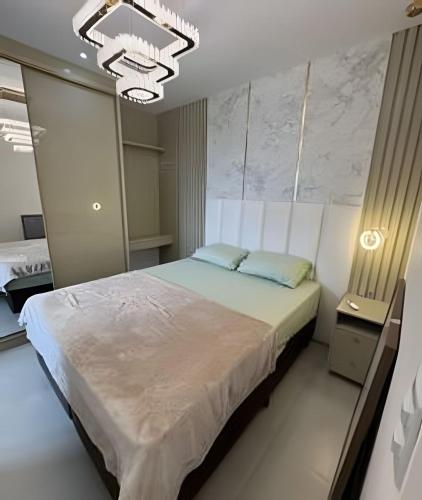 a bedroom with a bed and a chandelier at Itapema in Itapema