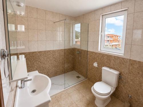 a bathroom with a toilet and a sink and a shower at M Apartments 2 in Bar