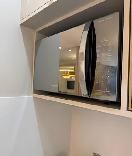 a microwave oven sitting inside of a cabinet at Itapema in Itapema
