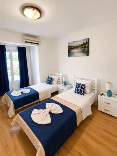 two beds in a room with blue and white at M Apartments 2 in Bar