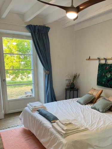 a bedroom with a large bed with a window at Pavilion de LaFue in Lavergne