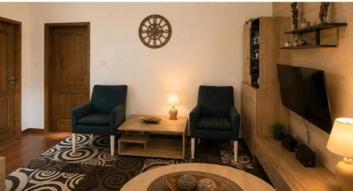 a living room with two chairs and a table and a tv at Seaside Apartments - Vasilije in Baošići