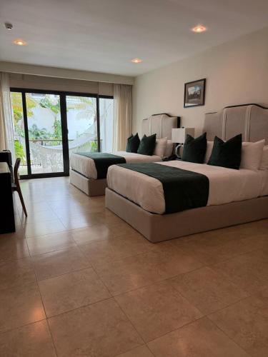 two beds in a large room with a large window at Hotel Gran David in Santiago