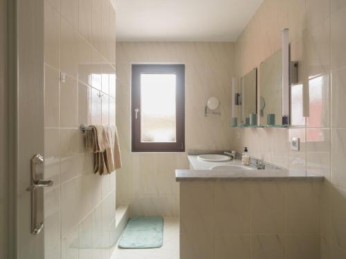 a white bathroom with a sink and a shower at Casa Zapato in La Pared