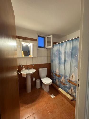 a bathroom with a toilet and a sink and a shower curtain at Dream Catcher 5 in Agia Theodoti